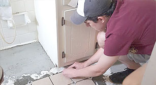 Volunteer repairing bathroom floor